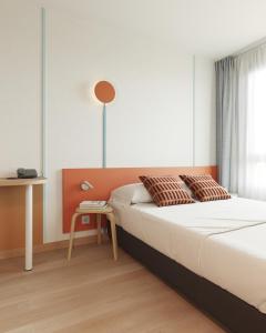 una camera con un grande letto e un tavolo di Aparthotel Adagio Access Toulouse Jolimont a Tolosa