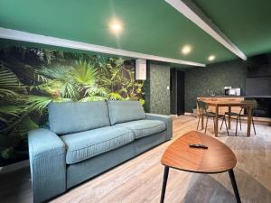 a living room with a blue couch and a table at Suite Tropical-Netflix-Parking in Douai