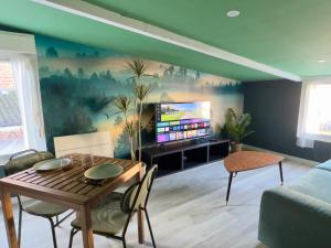 a living room with a table and a tv at Suite Tropical-Netflix-Parking in Douai