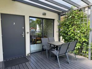 a patio with a table and chairs on a deck at Domki KREDKA in Jastarnia