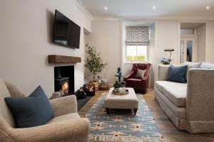 a living room with two couches and a fireplace at Coachman's, Kailzie in Peebles