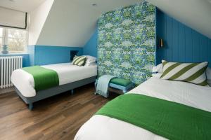 a bedroom with two beds and a blue wall at Coachman's, Kailzie in Peebles