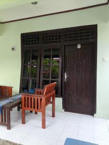a wooden bench sitting in front of a door at Gili Mesari Cottages & Homestay in Gili Trawangan