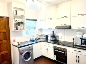 a kitchen with a washer and a washing machine at Plaisir de recevoir in Roodepoort