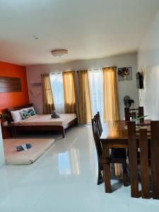 a living room with two beds and a dining table at CONDO unit in Puerto Princesa Palawan in Puerto Princesa City