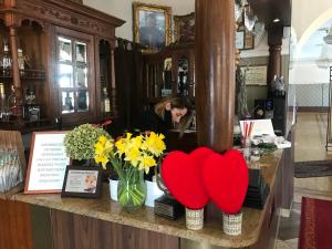 a woman behind a counter with two hearts and flowers at Kwatery w centrum Stary Rynek 4 a in Łowicz