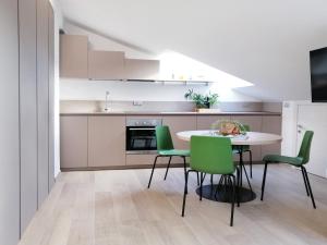 サン・ベネデット・デル・トロントにあるHolihome Be Loftのキッチン(テーブル、緑の椅子付)