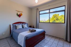 a bedroom with a bed with a cat laying on it at Apto confortavel a 450m do mar da Praia do Morro in Guarapari