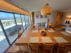 a living room with a table and a large window at Porto Neptune Terrace in Vila Nova de Gaia
