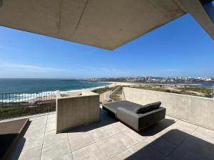a couch sitting on a patio overlooking the ocean at Porto Neptune Terrace in Vila Nova de Gaia
