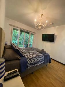 a bedroom with a bed and a couch and a chandelier at Brisa de rio Apartamento in La Chimba