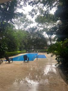 two benches in front of a swimming pool at Brisa de rio Apartamento in La Chimba +13 photos