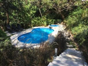 two small swimming pools in a yard with trees at Brisa de rio Apartamento in La Chimba