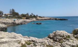 a large body of water with a rocky shore at Villa Mare Shabby Chic in Ognina