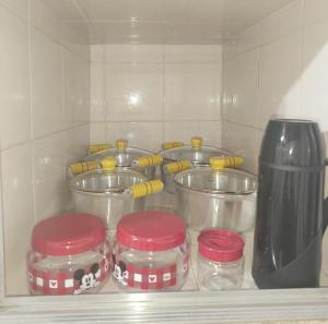 a shelf with four glass jars in a kitchen at Casa na Região Central in Cuiabá