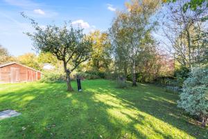 a green yard with trees and a house at Pretty Country Home Dog Friendly On Request in Henfield