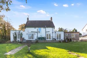 a large white house with a yard in front of it at Pretty Country Home Dog Friendly On Request in Henfield