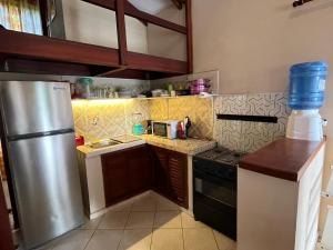 a small kitchen with a stainless steel refrigerator at Cabaña Las Retamas in Samaipata