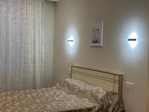 een slaapkamer met een bed en twee lampen aan de muur bij Qusar Apartment in Qusar