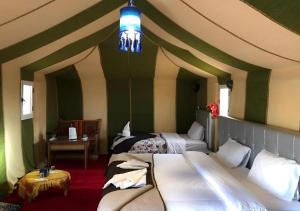 Postel nebo postele na pokoji v ubytování Merzouga Desert Palace Camp