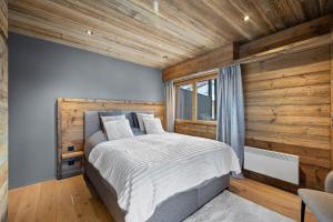 una camera da letto con un letto e una parete di legno di Grand-Place 16 - 7 pers - attique magnifique a Nendaz Altre 42 foto