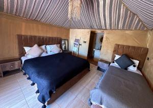 Postel nebo postele na pokoji v ubytování Merzouga Desert Palace Camp