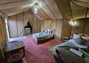 Postel nebo postele na pokoji v ubytování Merzouga Desert Palace Camp