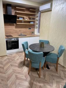 a kitchen with a table and chairs in a room at Pink Apartmani in Jagodina