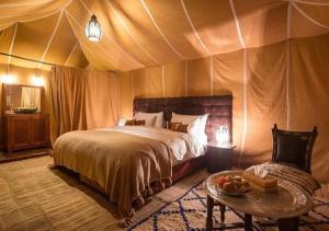 Postel nebo postele na pokoji v ubytování Merzouga Desert Palace Camp