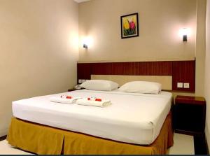 Sultan Syarif Kasim II International Airporthotel parma paus的一间卧室配有一张带两个白色枕头的大床