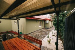 un banco de madera sentado bajo una pérgola de madera en Villa Shalom, en Cluj-Napoca