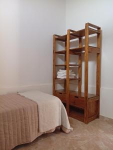 une chambre avec une étagère à côté d'un lit dans l'établissement Departamento Parque Norte, à San Rafael 1 autre photo