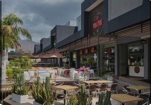 a restaurant with tables and chairs in front of a building at Edificio Mar de Leva in Santa Marta