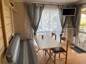 a table and chairs in a room with a window at Mobil home in Angles