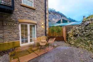 Stony MiddletonにあるRock Mill - Superior Apartment with Private Patioの建物の前にパティオ(テーブル、椅子付)