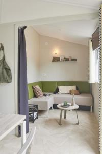 Camping Beau Rivage في Navarrenx: غرفة معيشة بها أريكة وطاولة