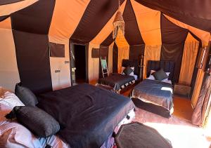 Postel nebo postele na pokoji v ubytování Merzouga Desert Palace Camp