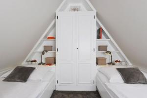 a room with two beds and a white closet at Bahnhofstraße 22B in Keitum