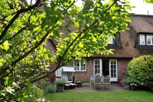 a brick house with a table and chairs in the yard at Bahnhofstraße 22B in Keitum
