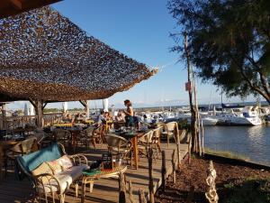 a wooden deck with tables and chairs next to a marina at Le Cochat in Andernos-les-Bains