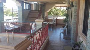 balcón con escaleras, mesa y sillas en Eden Travellers Lodge, en Puerto Princesa City