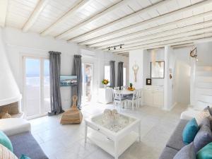 a living room with a couch and a table at The Mykonian Sunset Villas - 10min from Town in Agios Ioannis Mykonos