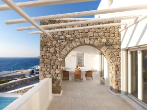 an archway in a villa with a view of the ocean at The Mykonian Sunset Villas - 10min from Town in Agios Ioannis Mykonos