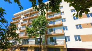 an apartment building with a tree in front of it at Gold House in Bucharest