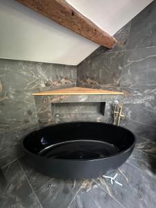 - une baignoire noire dans une chambre dotée d'un mur en pierre dans l'établissement Prior Hall Farm Cottage - 3 bedroom luxury cottage in center of Malham, à Malham 19 autres photos