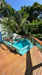 una terrazza in legno con piscina su una terrazza in legno di Altavista residence a Morro de São Paulo