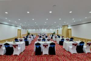 a banquet hall with white tables and chairs at The Luxant Hotel in Bengaluru