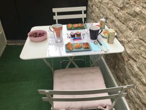 ein weißer Tisch mit einem Tablett voller Donuts darauf in der Unterkunft Le Déo in Pommiers