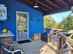 a patio with a blue wall and chairs on a deck at El Raitín in Ruiloba