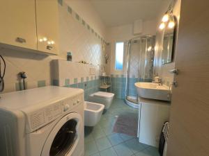 a bathroom with a washing machine and a sink at Riviera Charme House in San Bartolomeo al Mare